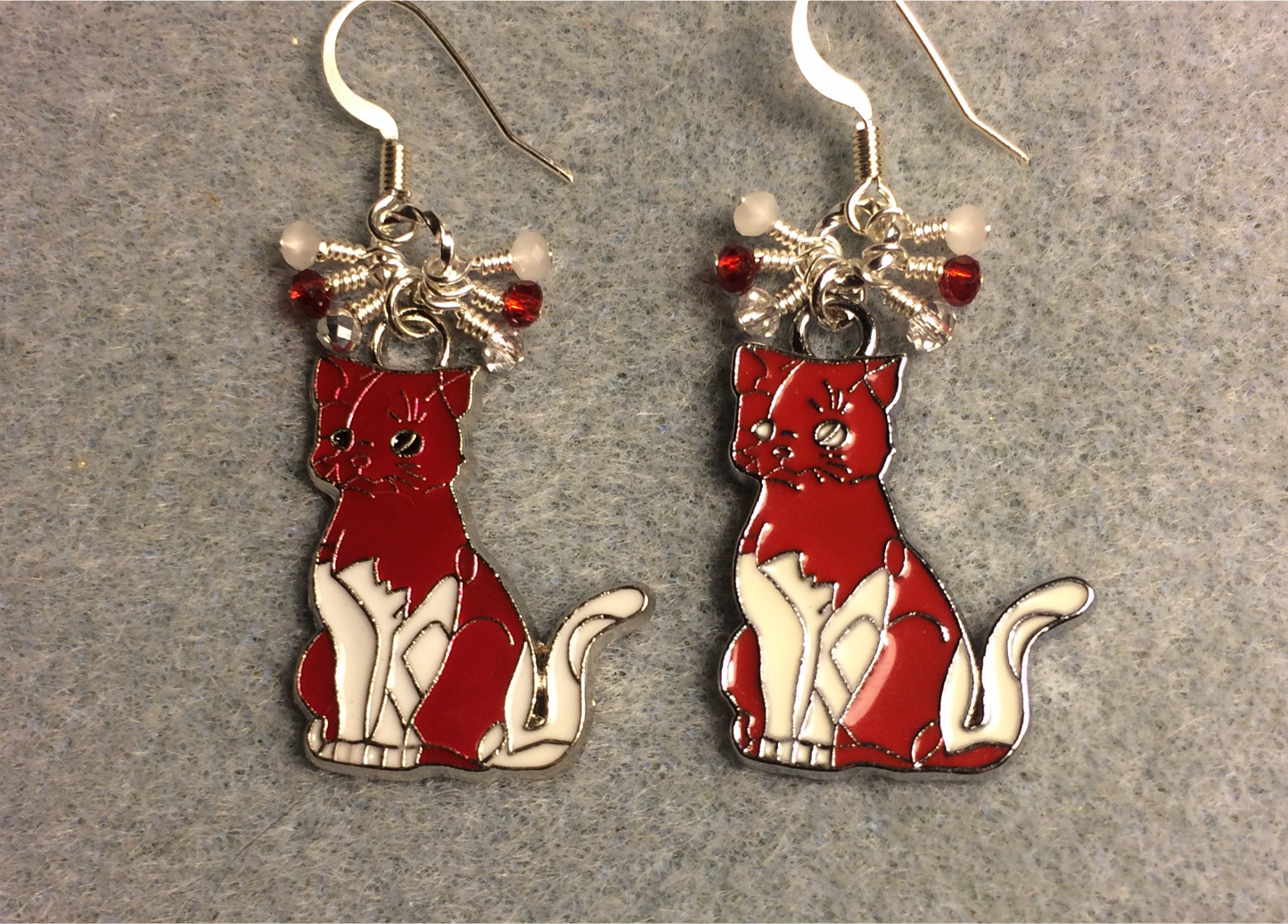 Red and white enamel cat charm earrings adorned with tiny dangling red and white Chinese crystal beads.