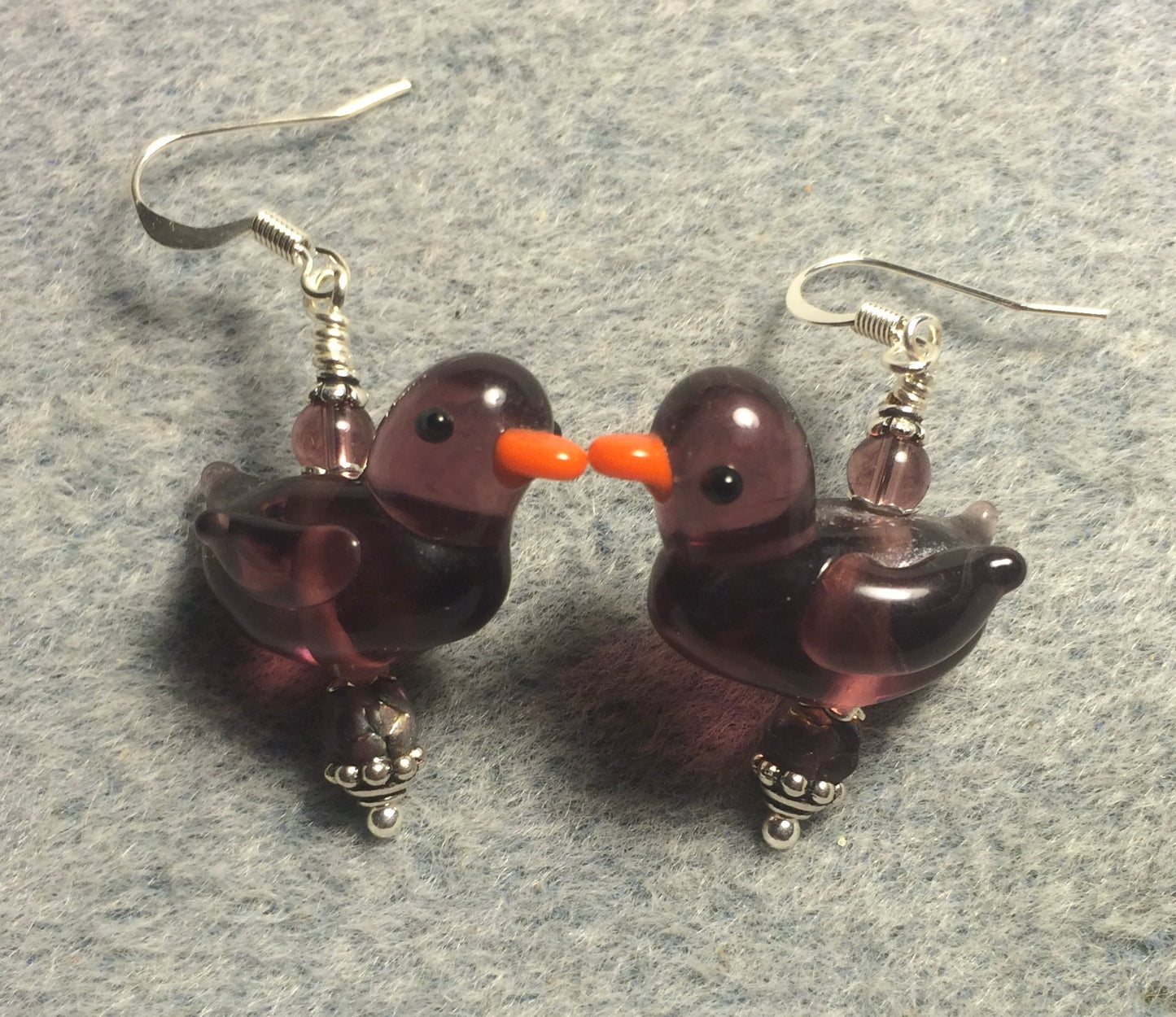 Translucent lavender lamp work duck bead earrings adorned with lavender Czech glass beads.