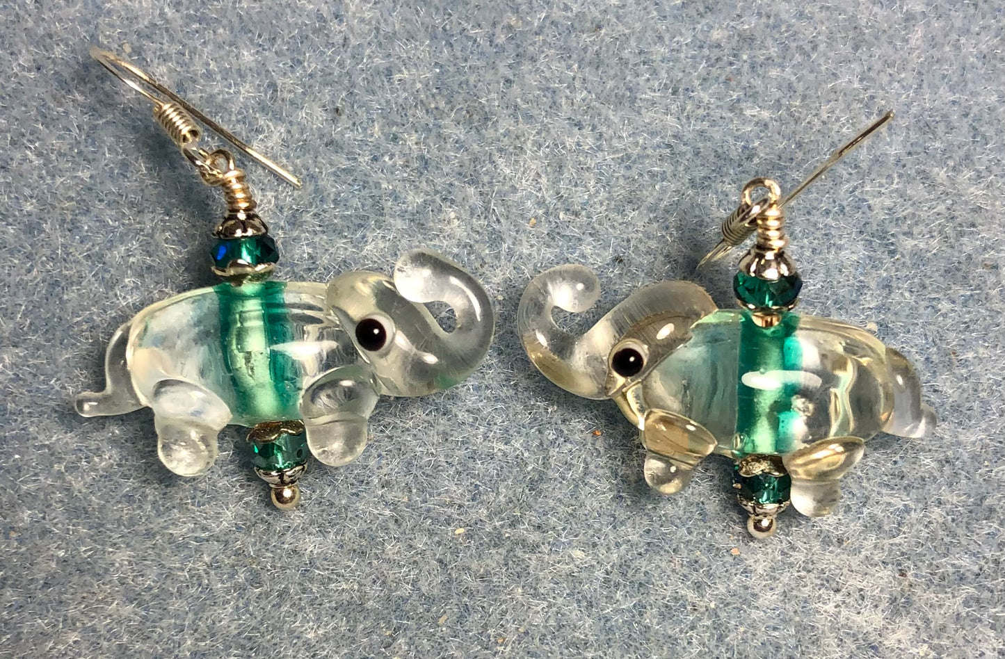 Clear and teal lamp work elephant bead earrings adorned with teal Chinese crystal beads.
