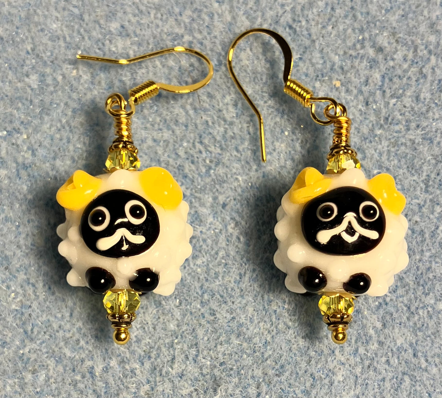 Small white, black, and yellow lamp work sheep bead earrings adorned with yellow Chinese crystal beads.