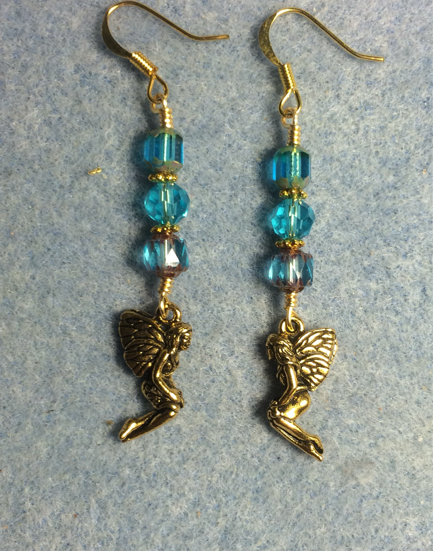 Gold Tierracast fairy charm earrings adorned with turquoise Czech glass beads