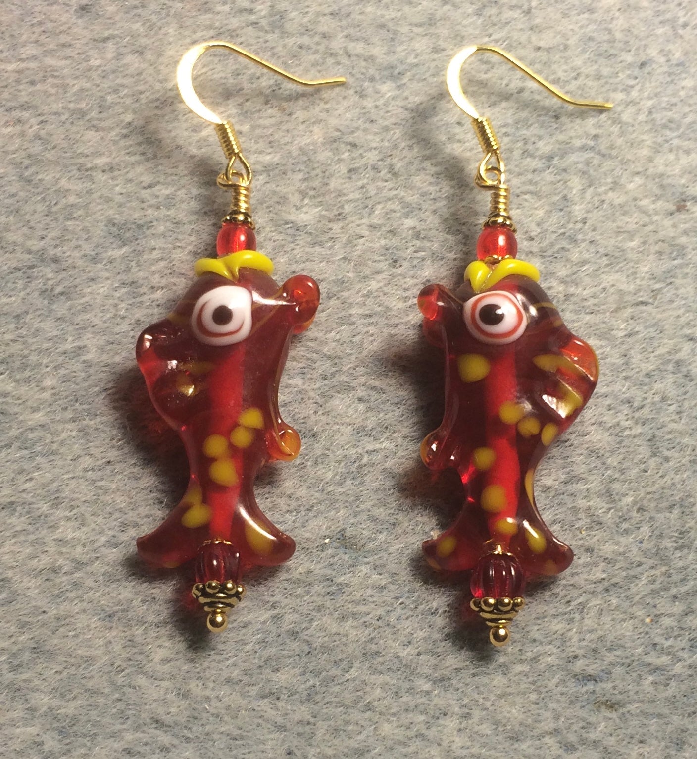 Red and yellow lamp work spotted fish bead earrings adorned with red Czech glass beads.