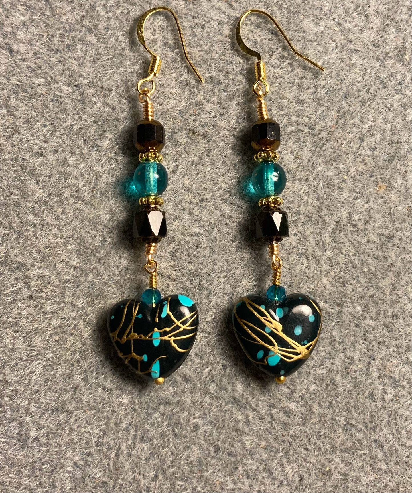 Black, turquoise, and gold acrylic heart bead earrings adorned with black and turquoise Czech glass beads.
