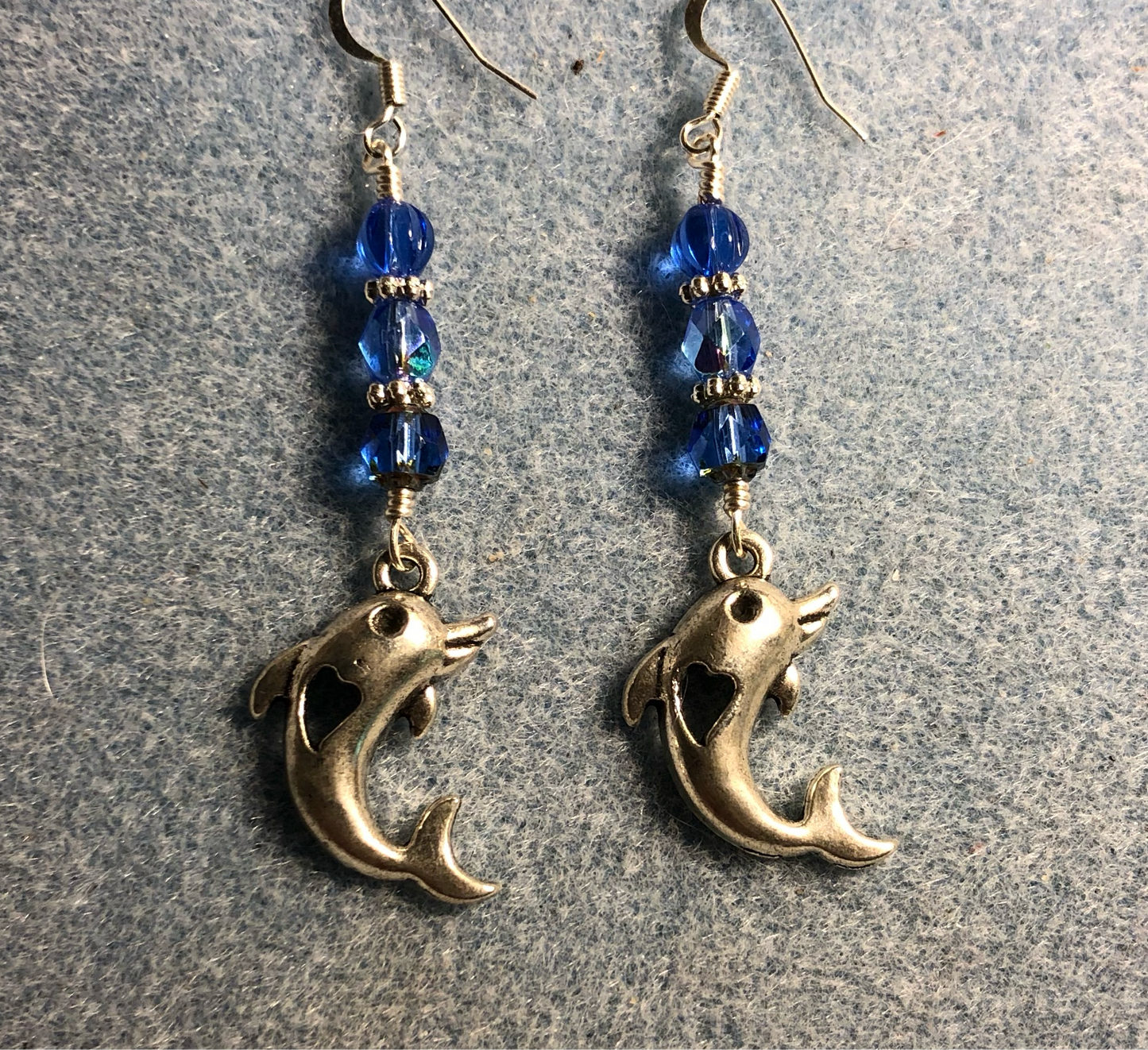 Silver dolphin charm earrings adorned with blue Czech glass beads