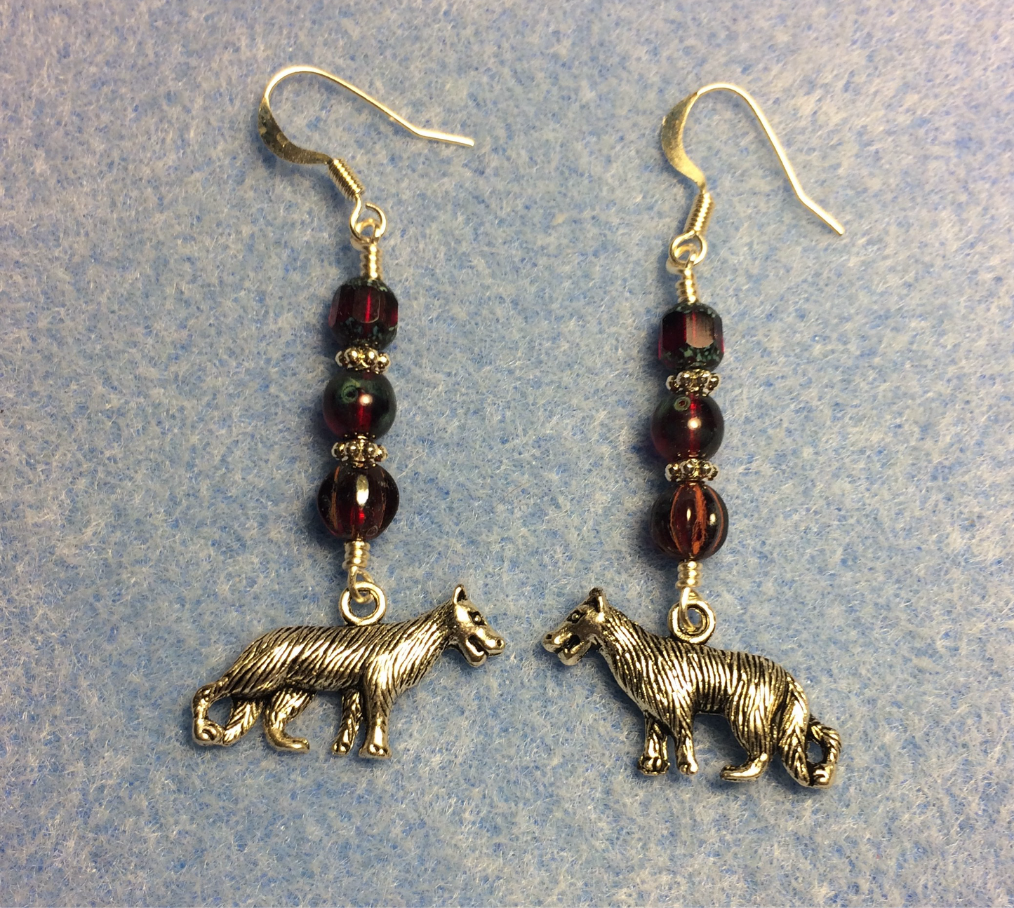 Silver wolf charm earrings adorned with dark red Czech glass beads