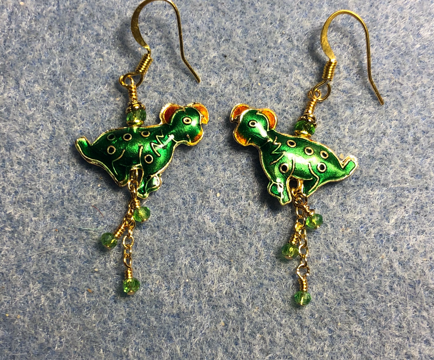 Green and white vintage cloisonné dog bead earrings adorned with gold chain and tiny green Chinese crystal beads.