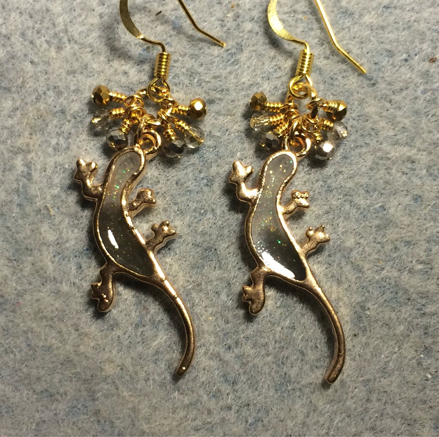 Gray and gold resin lizard charm earrings adorned with tiny dangling gray, clear, and gold Chinese crystal beads.