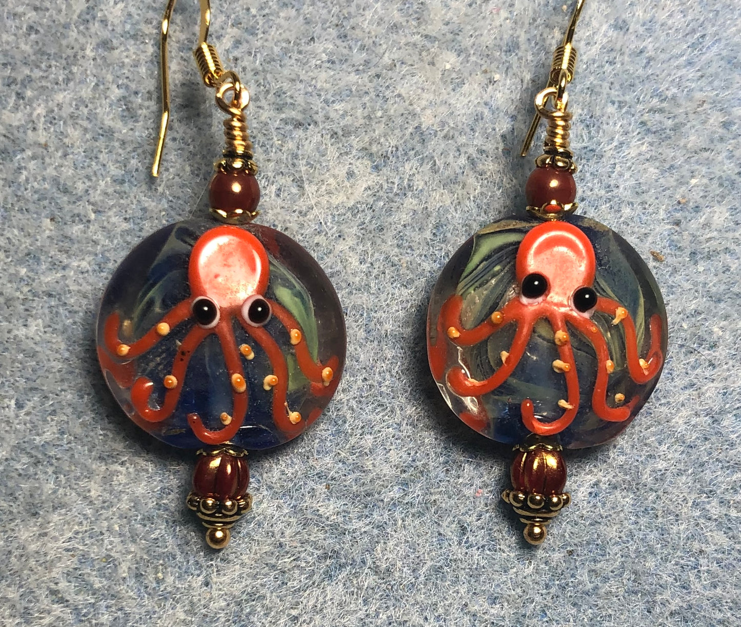 Blue and orange lamp work octopus bead earrings adorned with orange Czech glass beads.