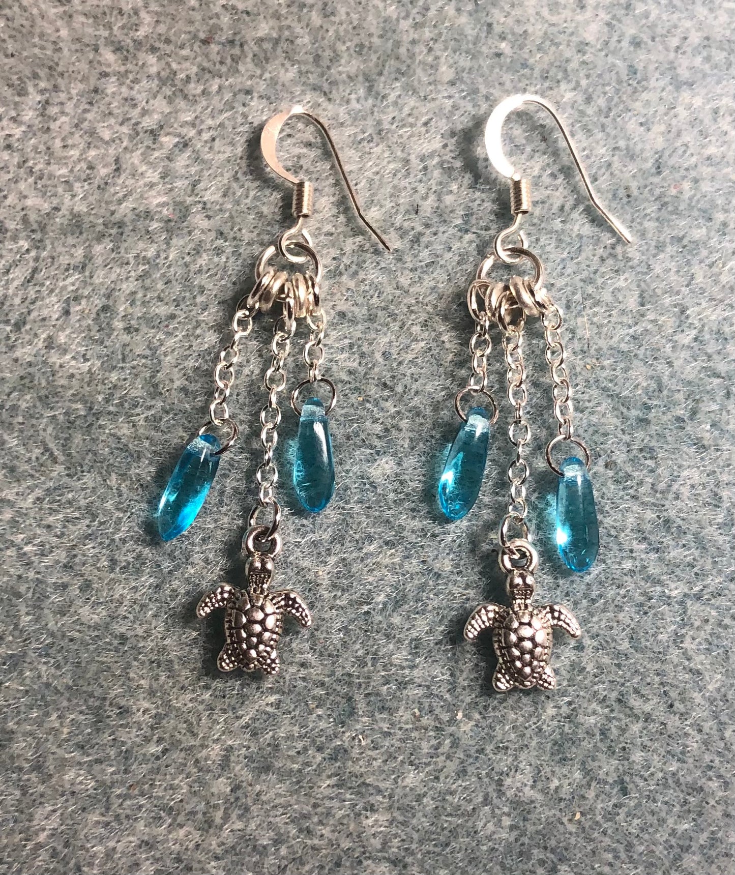 Small silver sea turtle charm earrings attached to silver chain and adorned with small turquoise Czech glass dagger beads