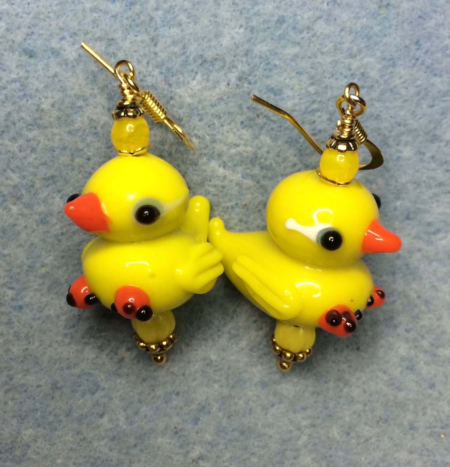 Yellow lamp work duck bead earrings adorned with yellow Czech glass beads.