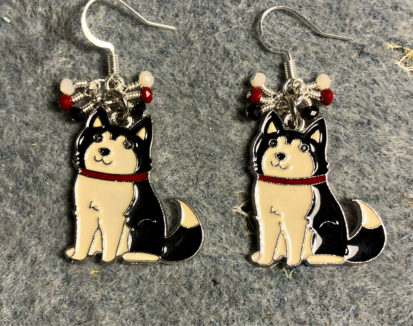 Black and white enamel Siberian Husky charm earrings adorned with tiny dangling black, white, and red Chinese crystal beads.