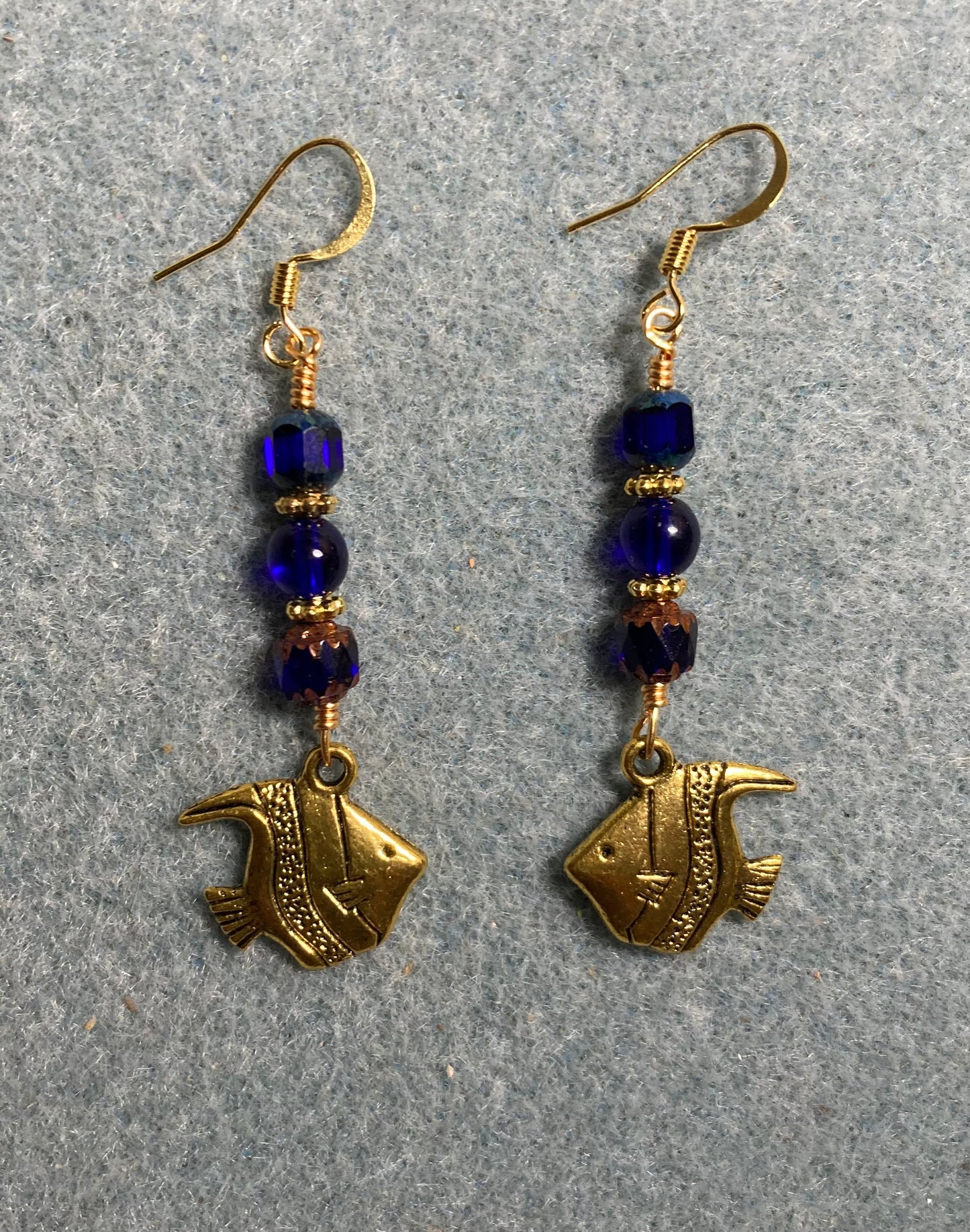 Gold angelfish charm earrings adorned with dark blue Czech glass beads