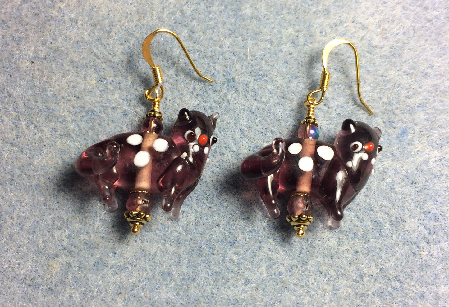 Translucent violet lamp work spotted cat bead earrings adorned with violet Czech glass beads.