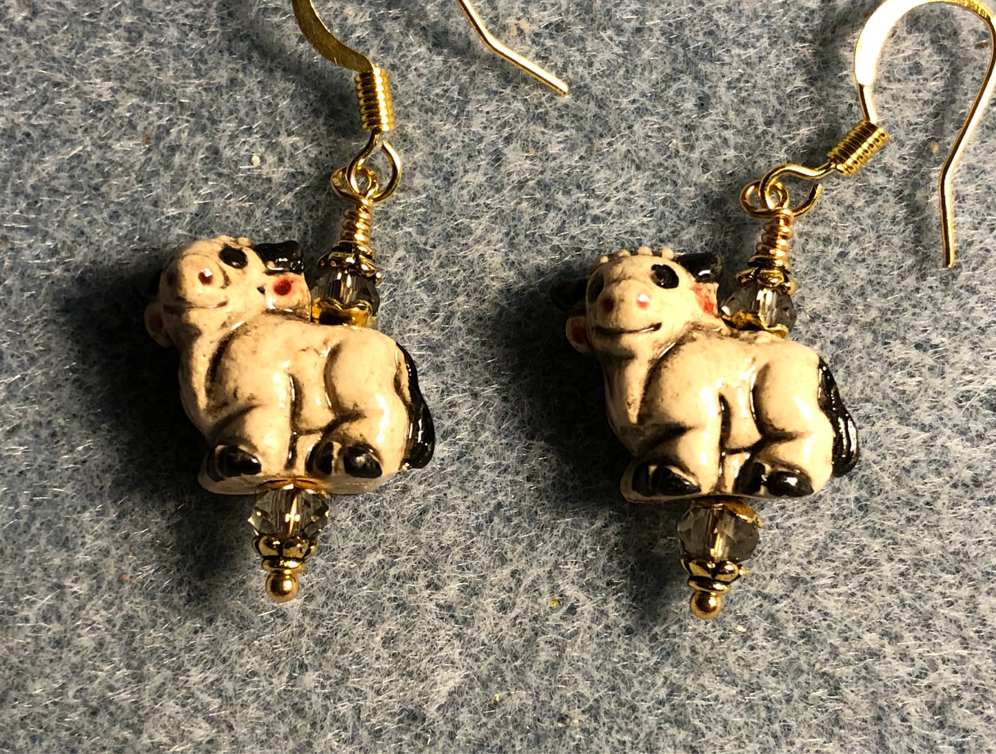 Small tan and black ceramic ram bead earrings adorned with tan Chinese crystal beads.
