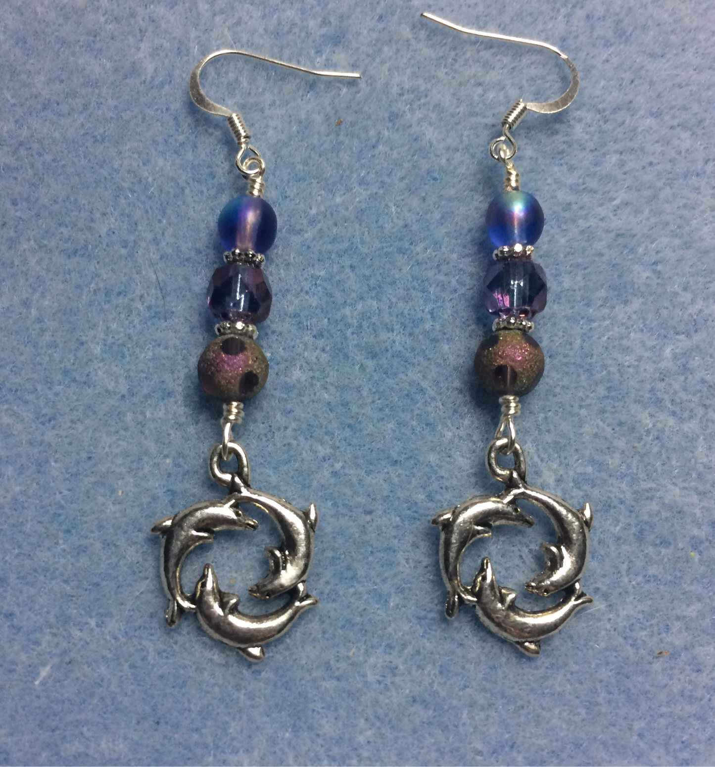 Silver circle of dolphin charm earrings adorned with purple Czech glass beads