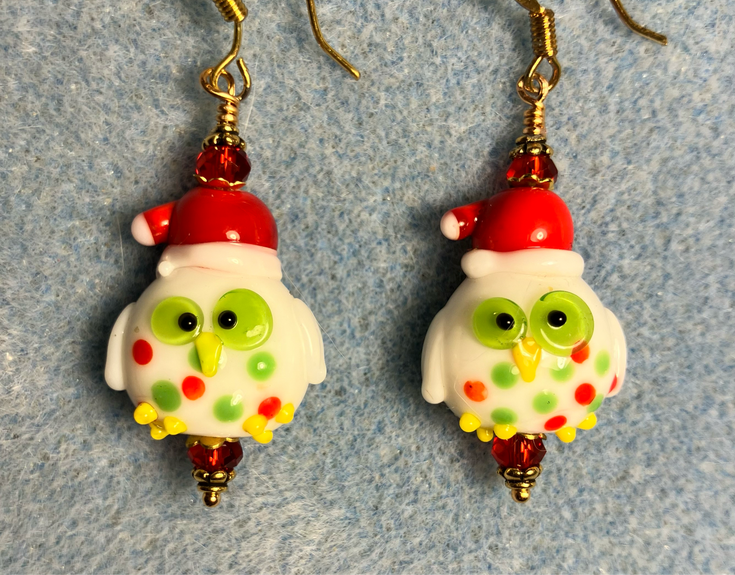 Red, green, and yellow lamp work Santa owl bead earrings adorned with red Chinese crystal beads.