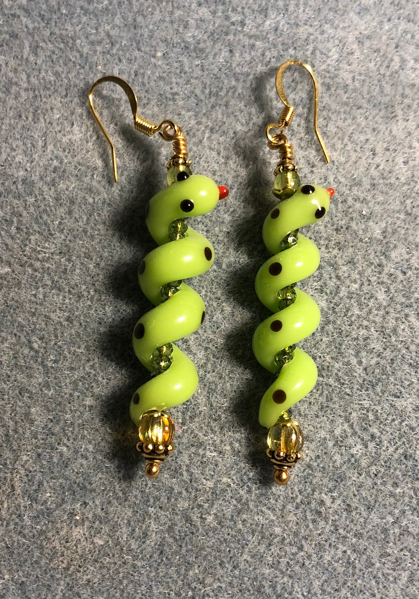 Olive green lamp work coiled snake bead earrings adorned with olive green Czech glass beads and tiny olive green Chinese crystal beads.