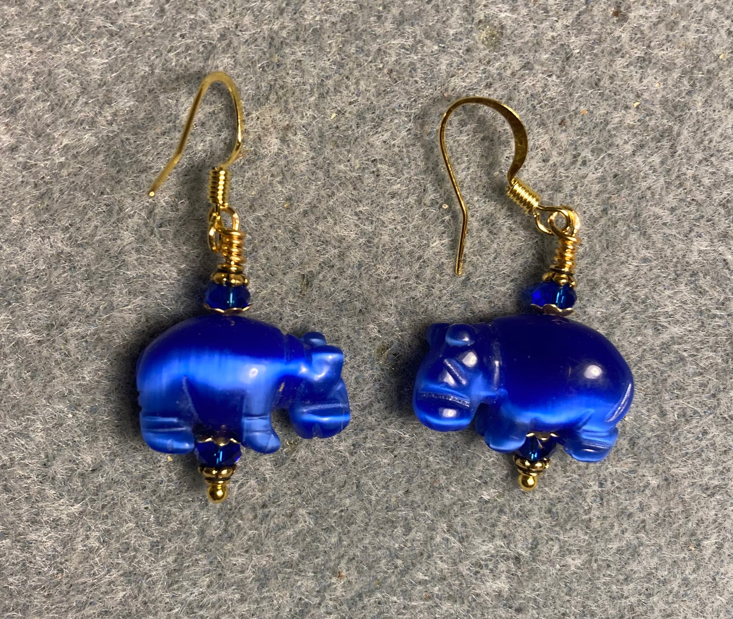 Blue fiber optic (cat’s eye)hippo bead earrings adorned with dark blue Chinese crystal beads.