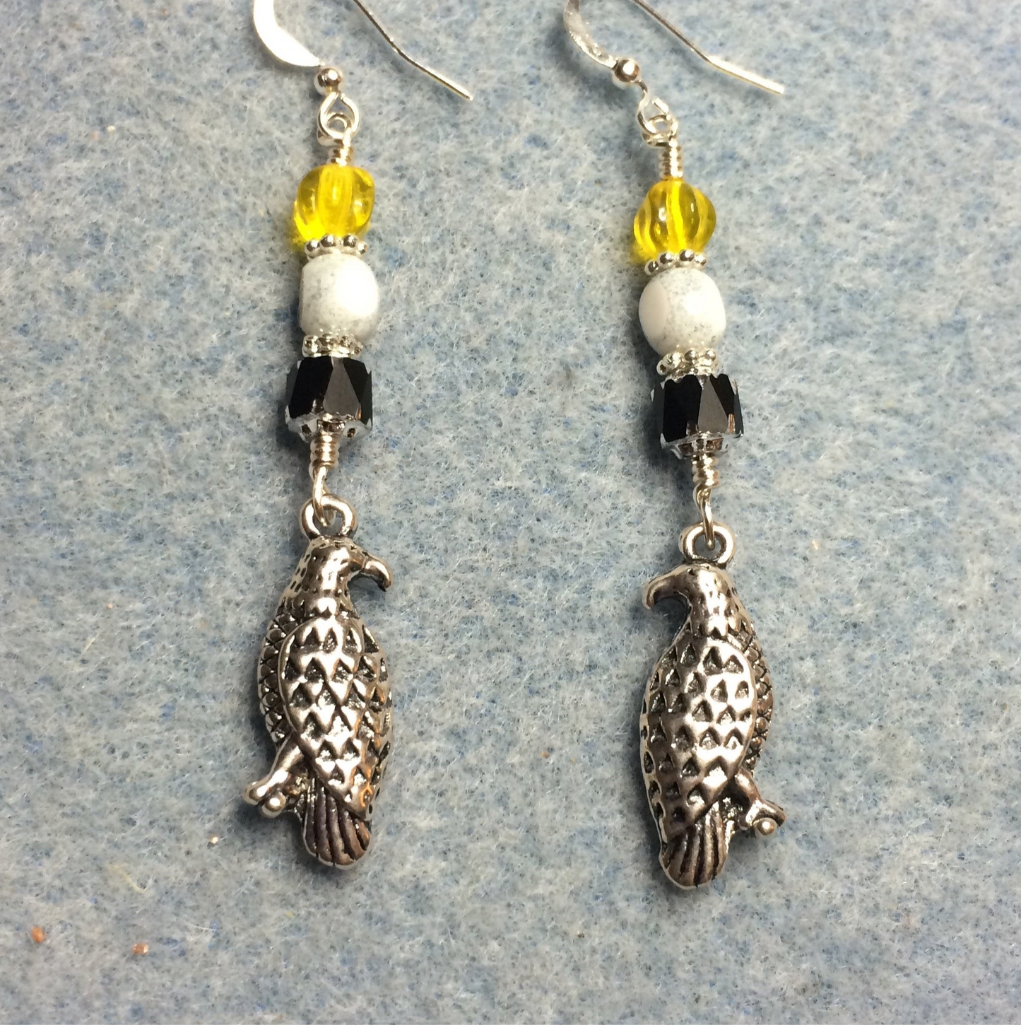 Silver eagle charm earrings adorned with black, white, and yellow Czech glass beads