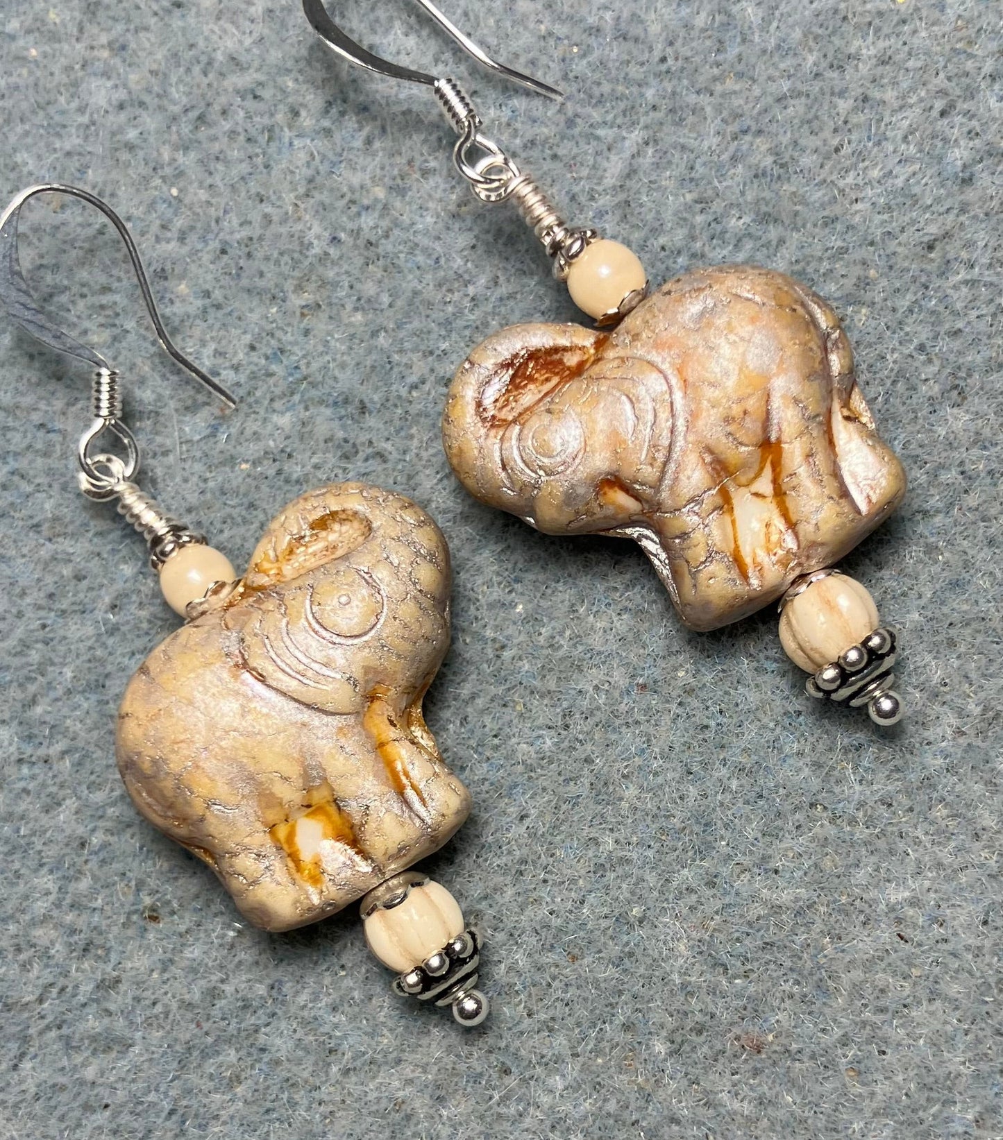Creamy beige (with silver inlay) Czech glass elephant bead earrings adorned with cream Czech glass beads.