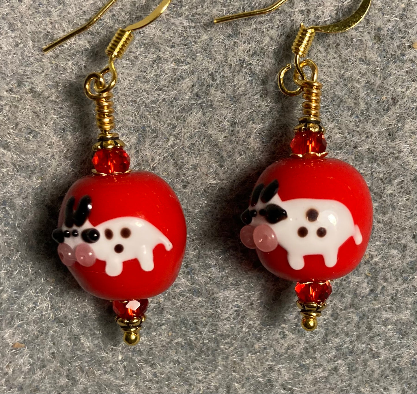 Red, white, and black lamp work cow bead earrings adorned with red Chinese crystal beads.
