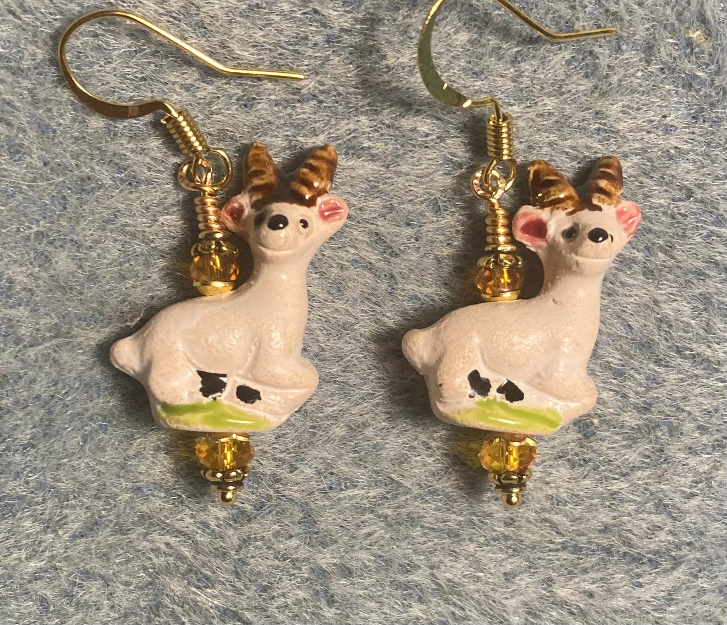 Small beige and amber ceramic goat bead earrings adorned with amber Chinese crystal beads.