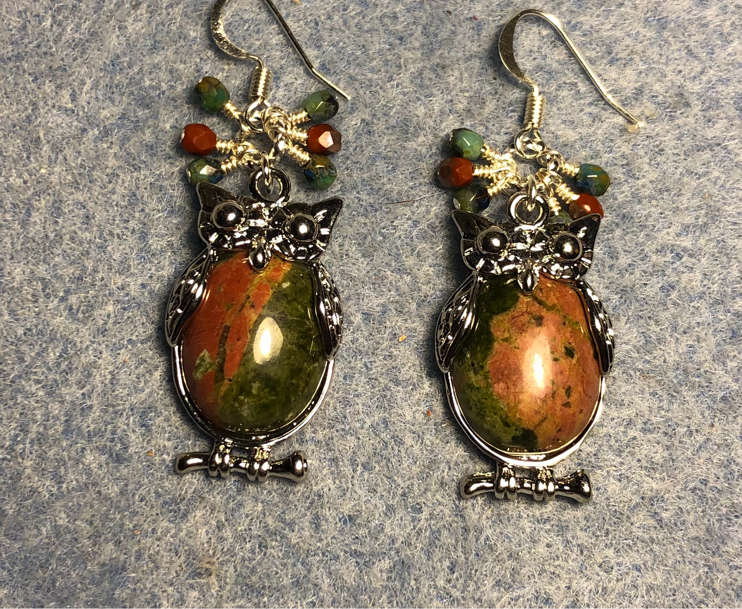 Large silver and green and orange unakite gemstone owl charm earrings adorned with small dangling green and orange Czech glass beads.