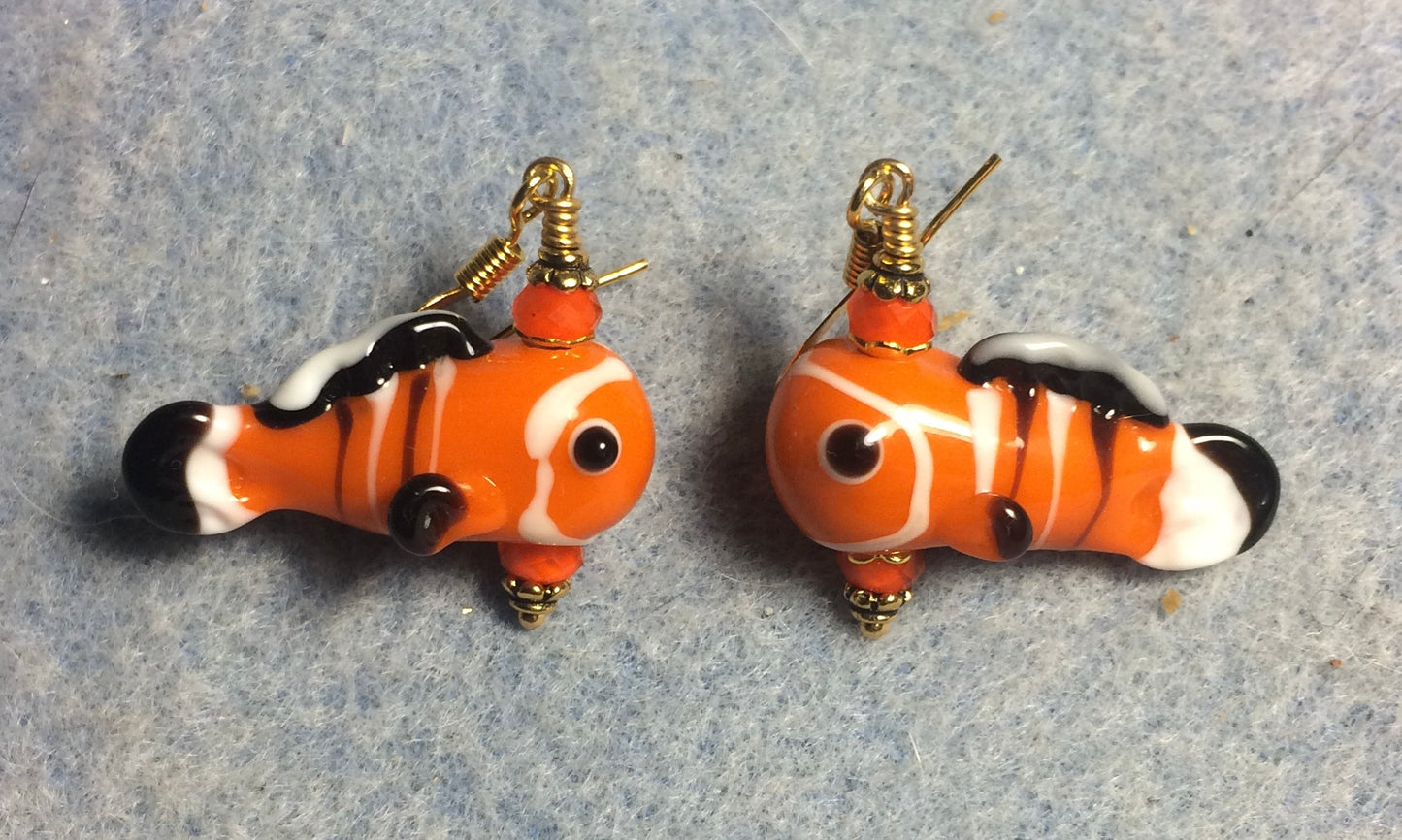 Orange, black, and white lamp work fish bead earrings adorned with orange Chinese crystal beads.