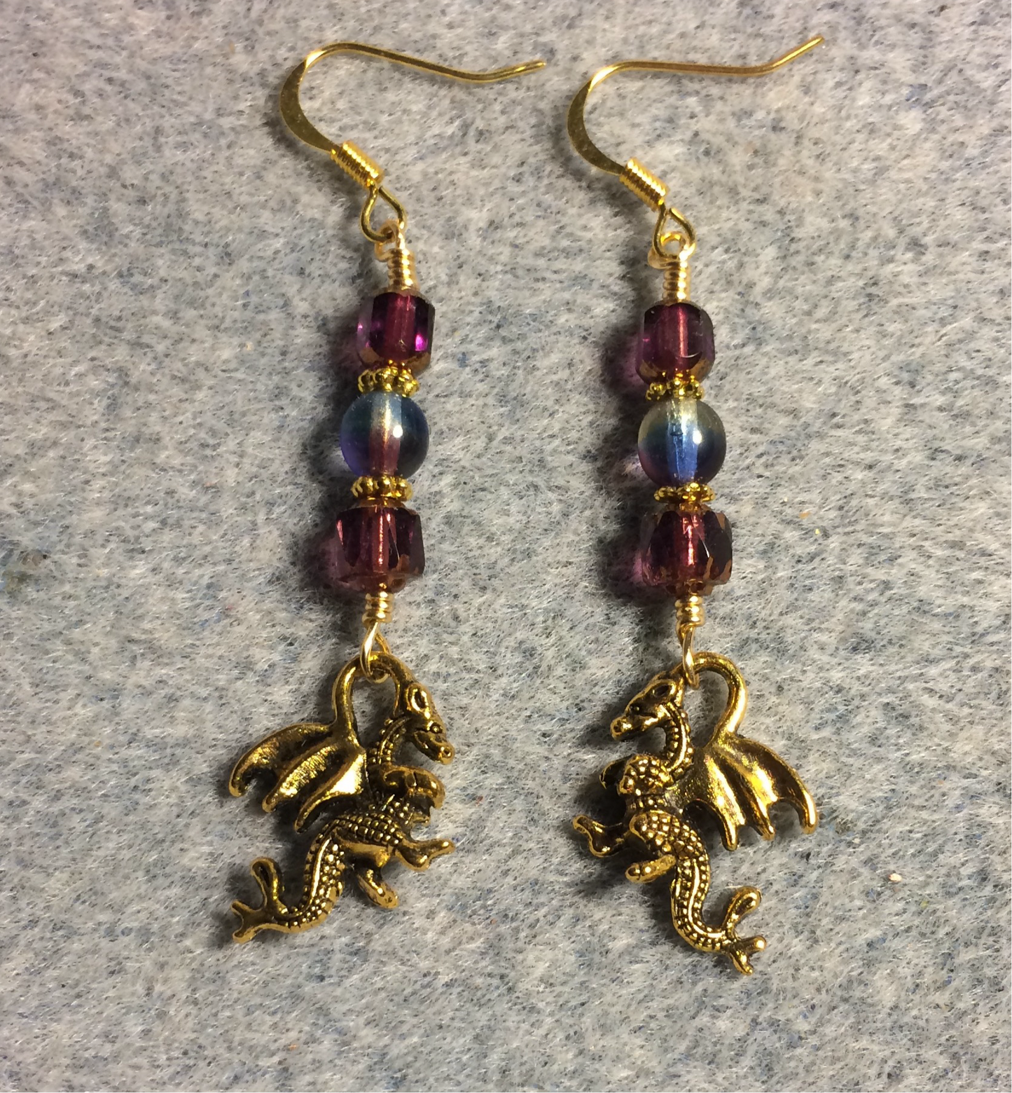 Gold dragon charm earrings adorned with purple Czech glass beads