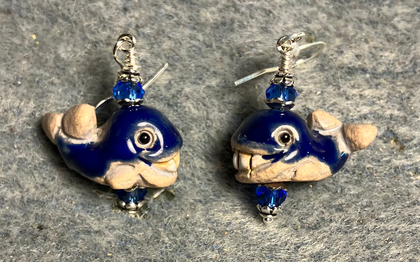 Small beige and dark blue ceramic whale bead earrings adorned with dark blue Chinese crystal beads.