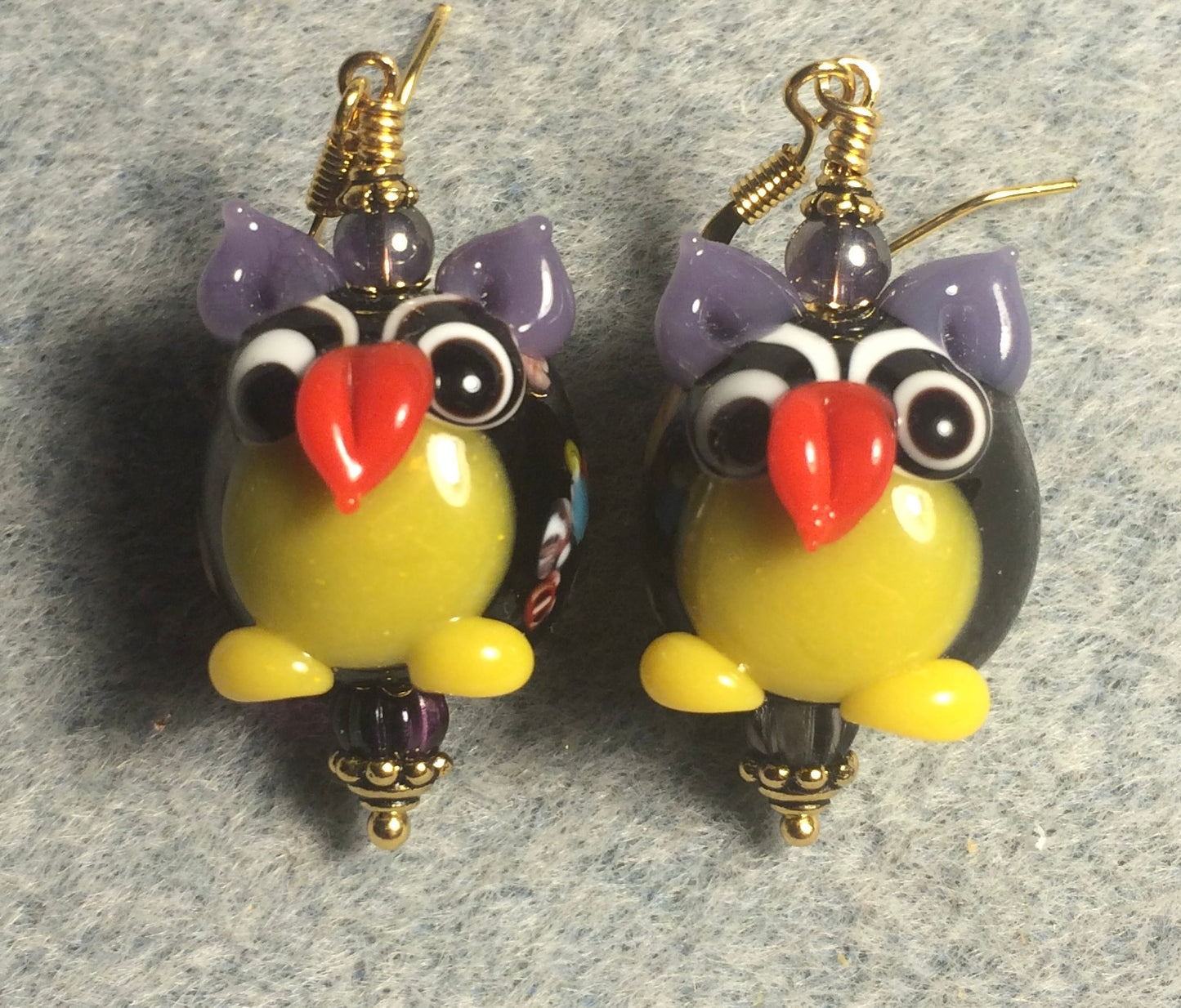Purple and yellow lamp work owl bead earrings adorned with purple Czech glass beads.