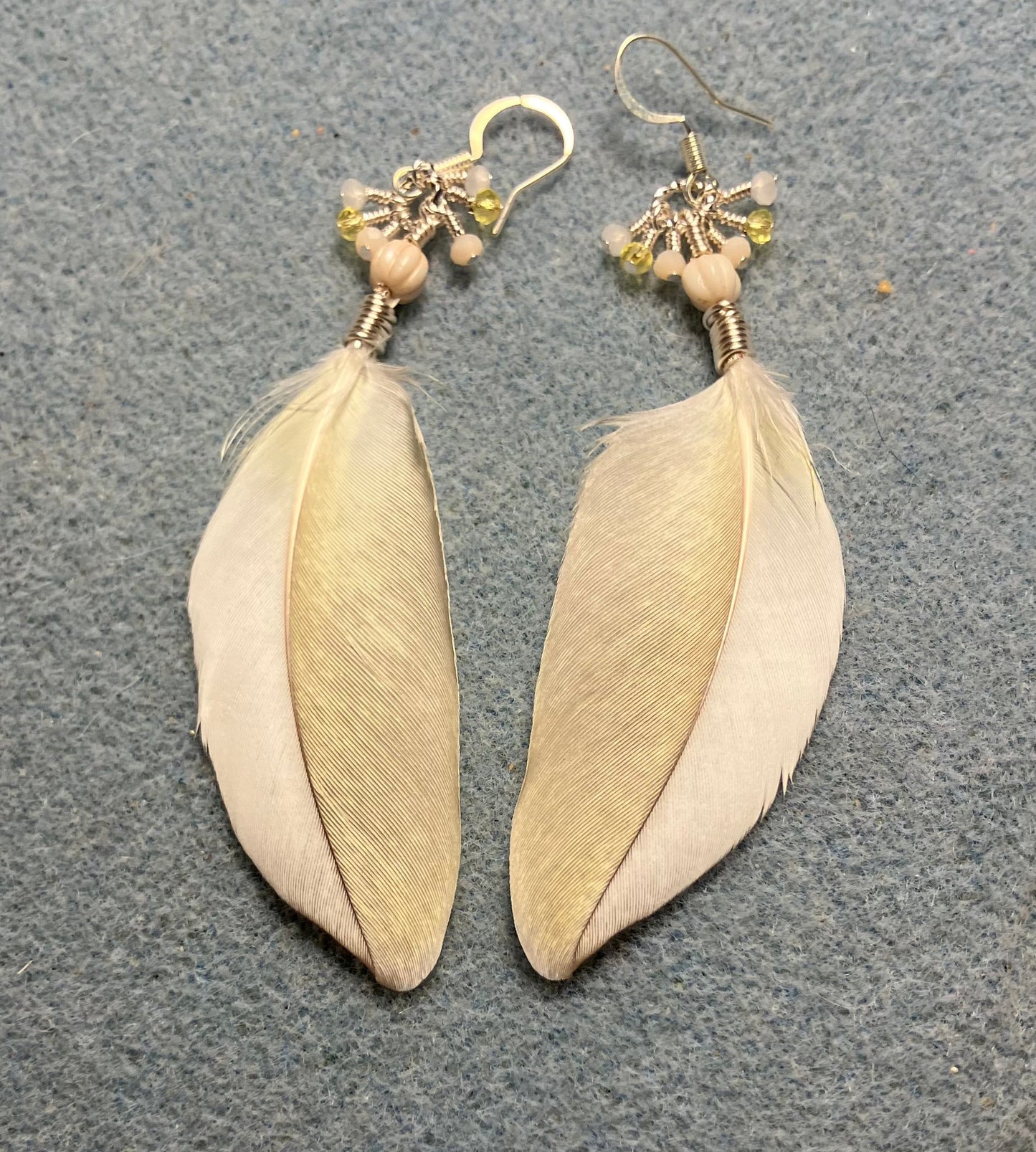 White and yellow cockatiel feather earrings adorned with white Czech glass melon beads and tiny dangling white and yellow Chinese crystal beads.