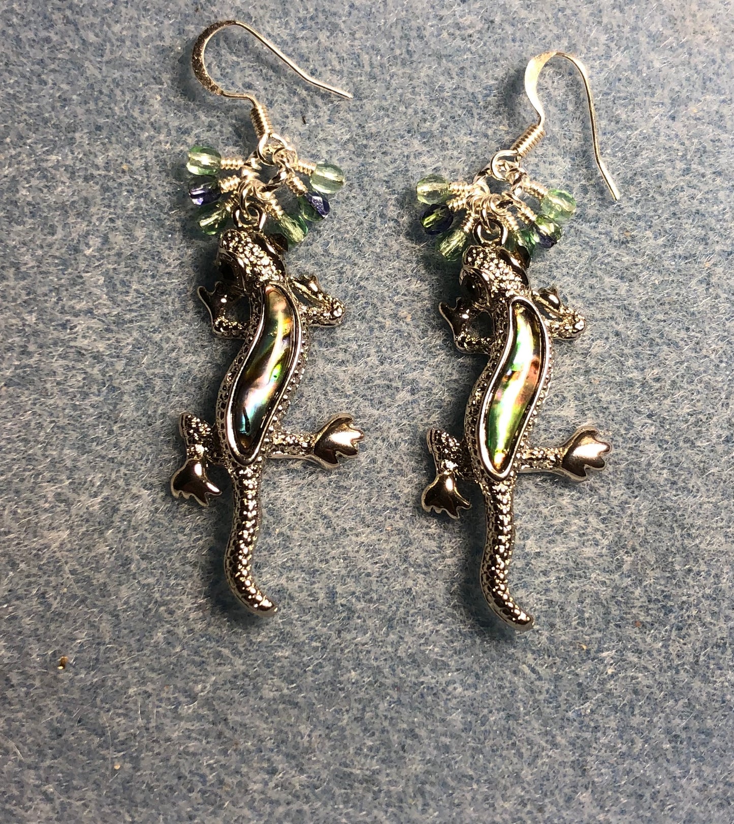 Silver and abalone lizard charm earrings adorned with small dangling light green Czech glass beads.