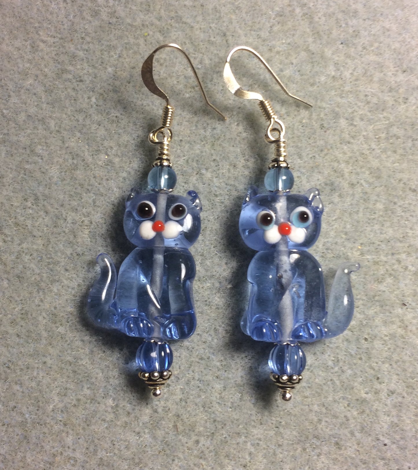 Translucent light blue lamp work cat bead earrings adorned with light blue Czech glass beads.