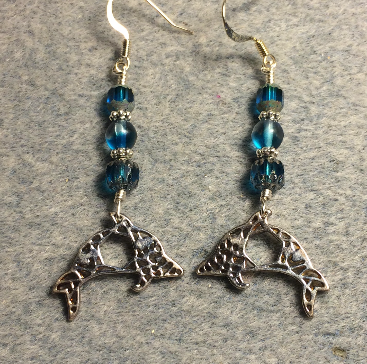 Ornate silver dolphin charm earrings adorned with turquoise Czech glass beads