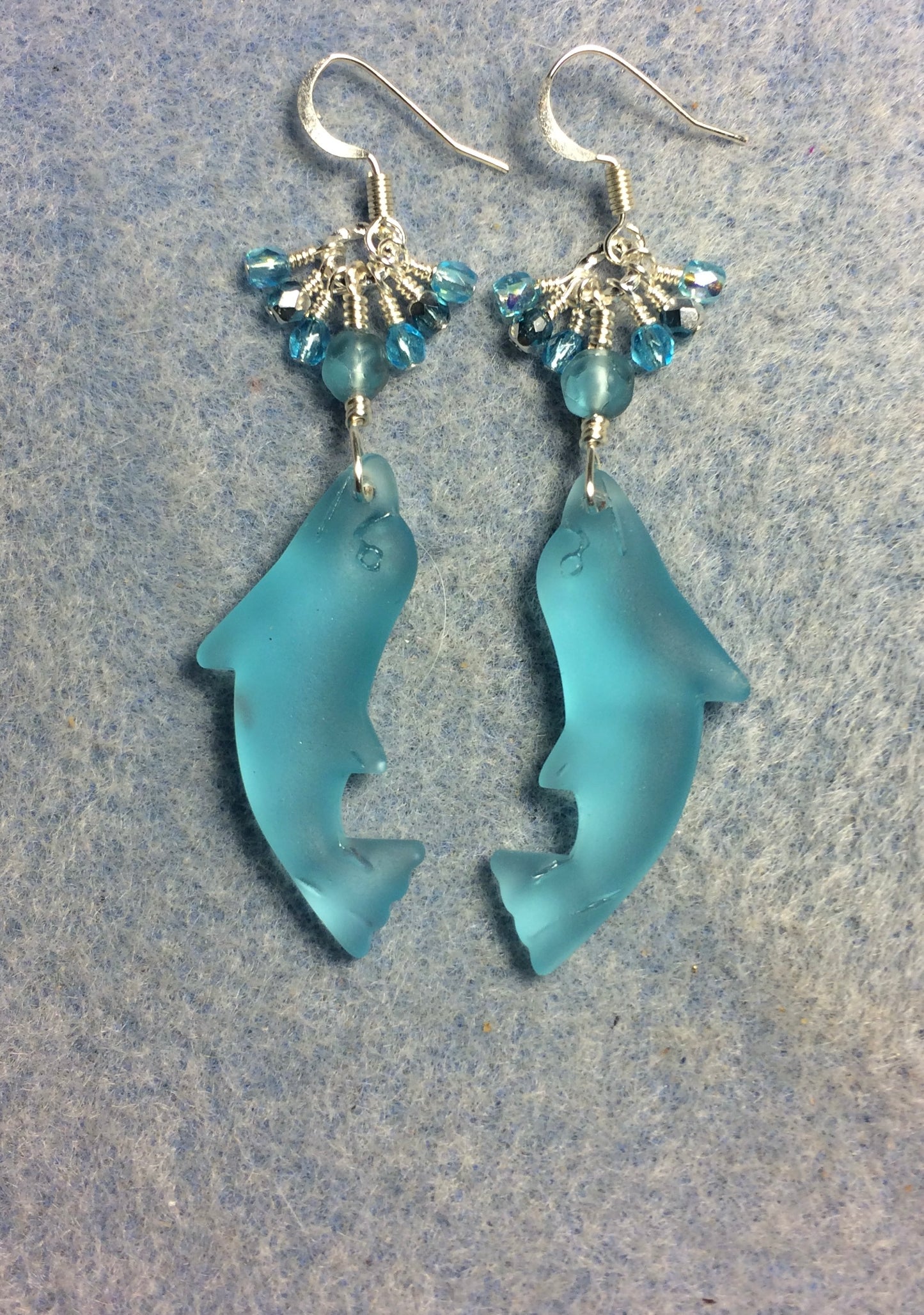 Light turquoise sea glass dolphin pendant bead earrings adorned with light turquoise Czech glass beads and tiny dangling light turquoise Czech glass beads.