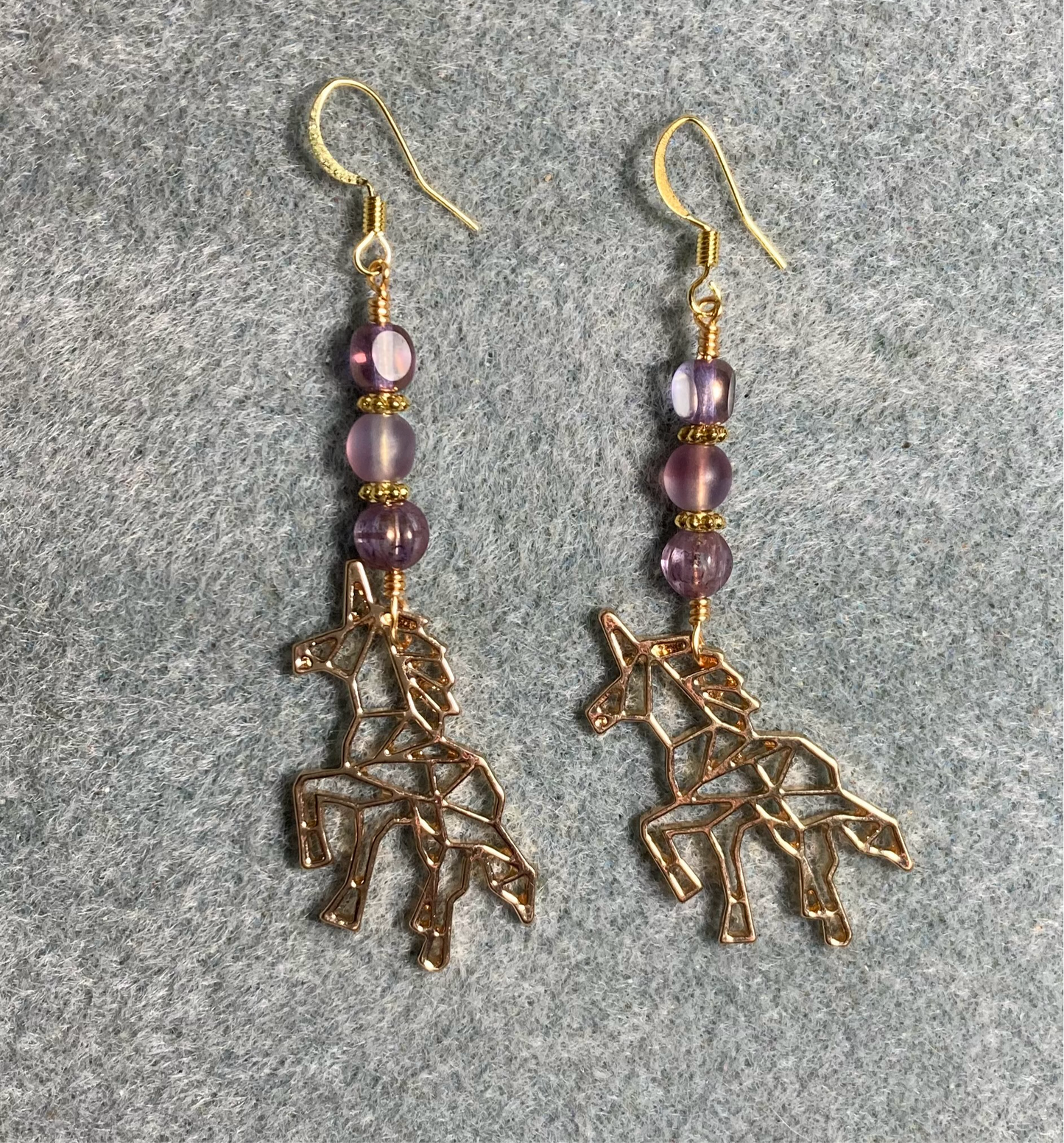 Large gold unicorn charm earrings adorned with violet Czech glass beads