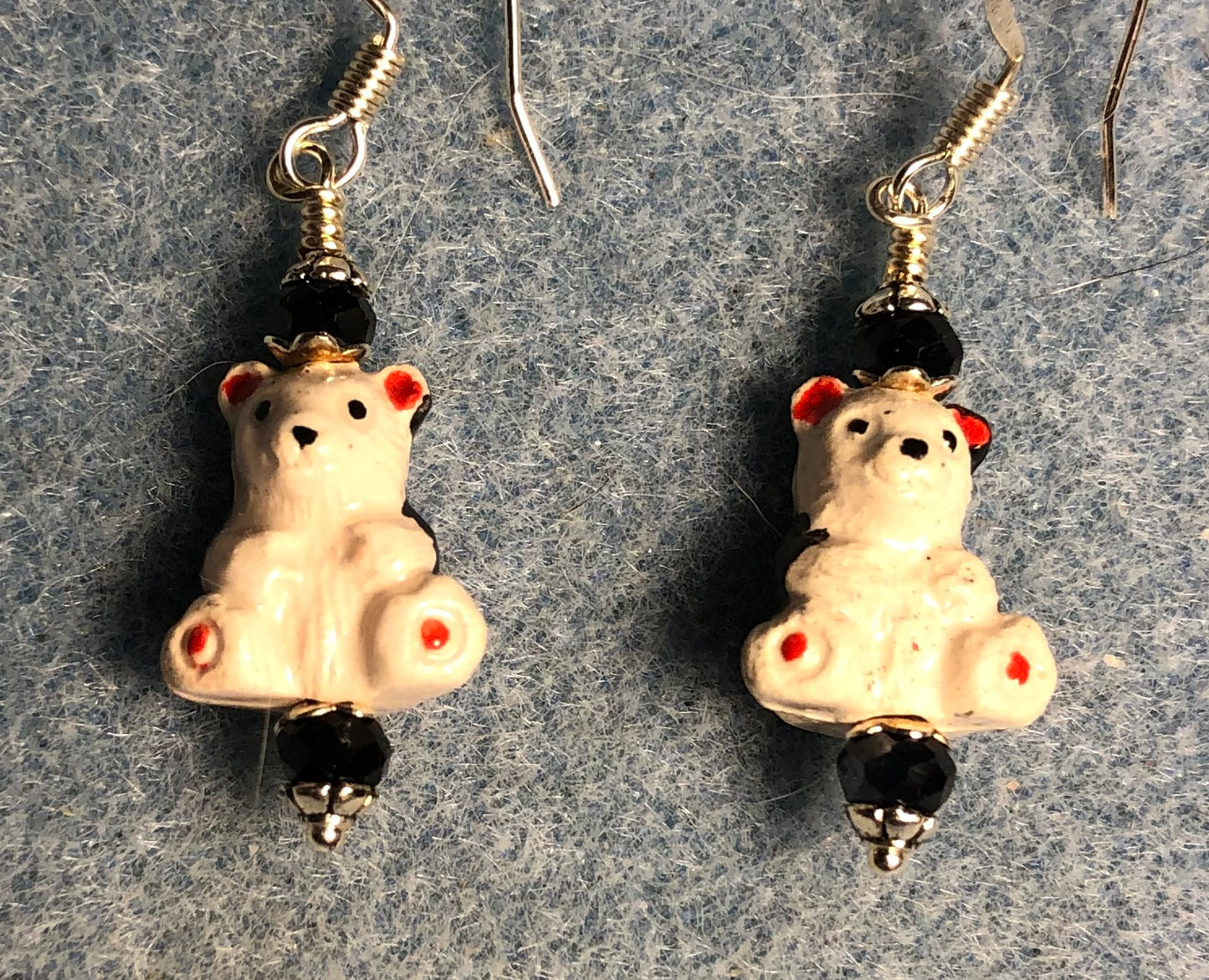 Small white and black ceramic teddy bear bead earrings adorned with black Chinese crystal beads.