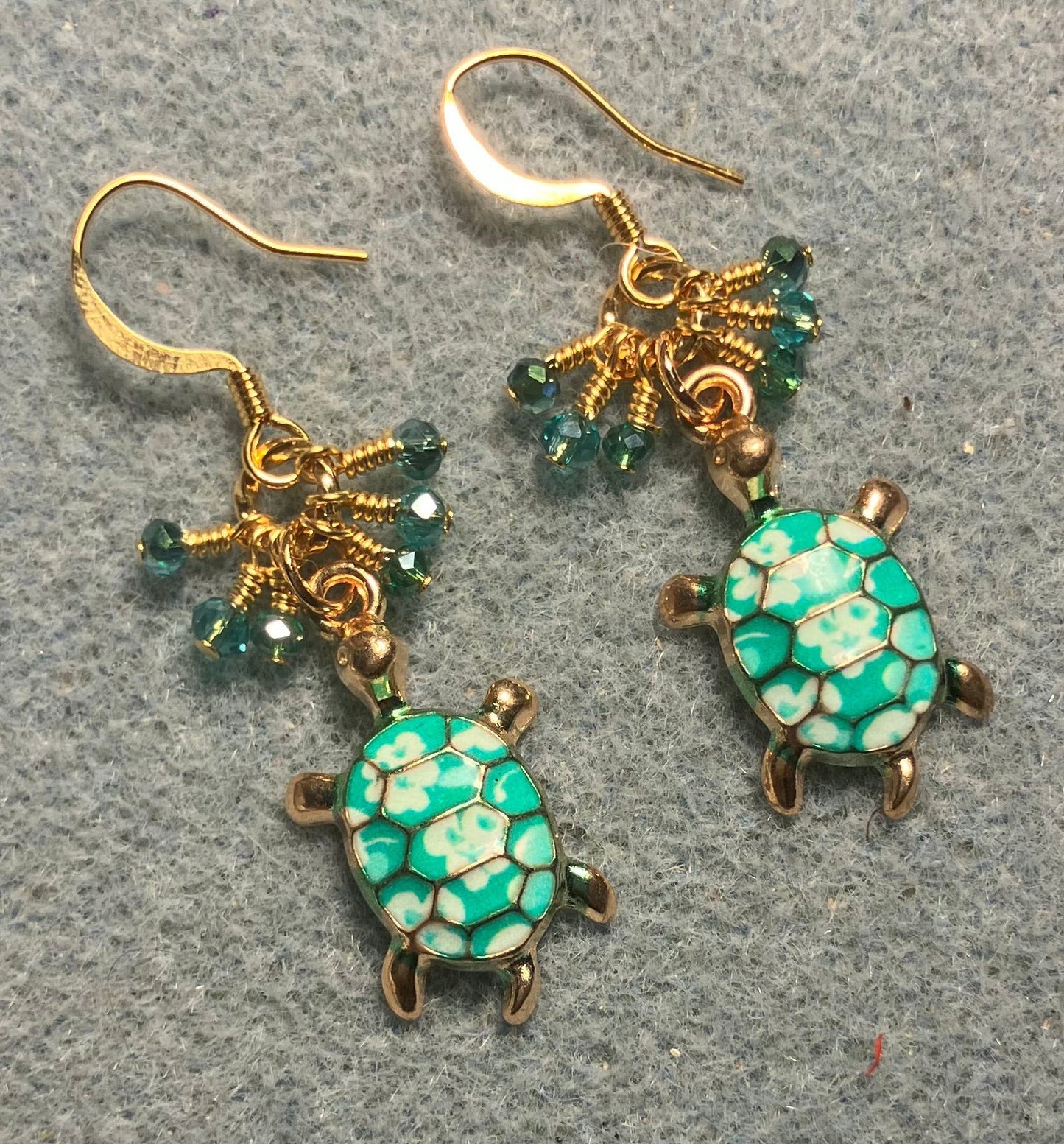 Teal and white enamel turtle charm earrings adorned with tiny dangling teal Chinese crystal beads.