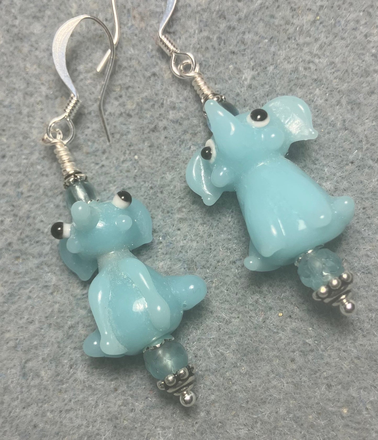 Opaque light aqua lamp work sitting elephant bead earrings adorned with light aqua Czech glass beads.