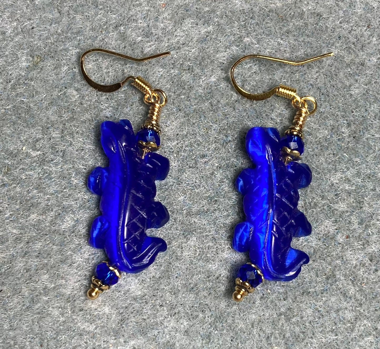 Dark blue fiber optic (cat’s eye) lizard bead earrings adorned with dark blue Chinese crystal beads.