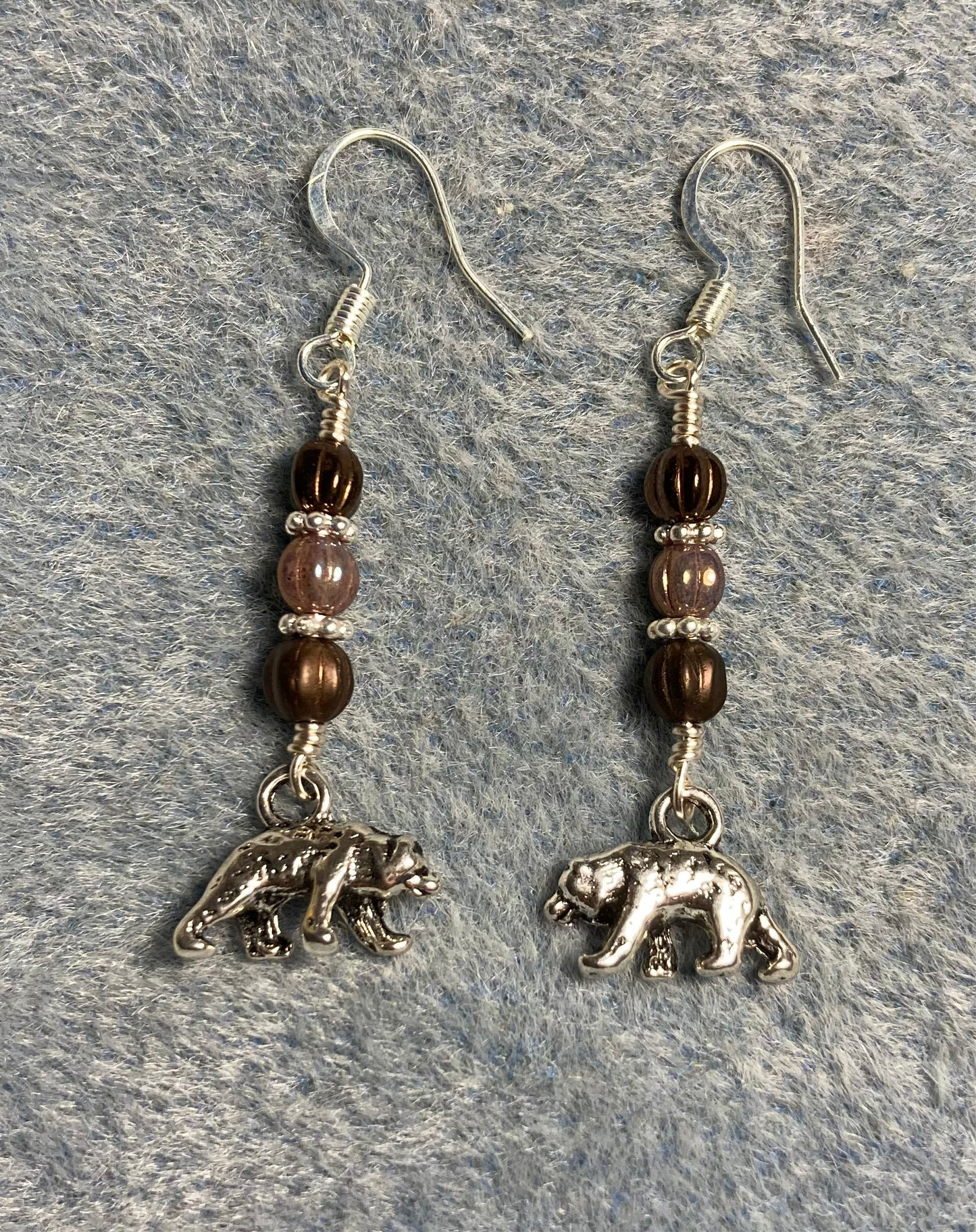 Long silver jumping frog charm earrings adorned with olive green Czech glass beads.