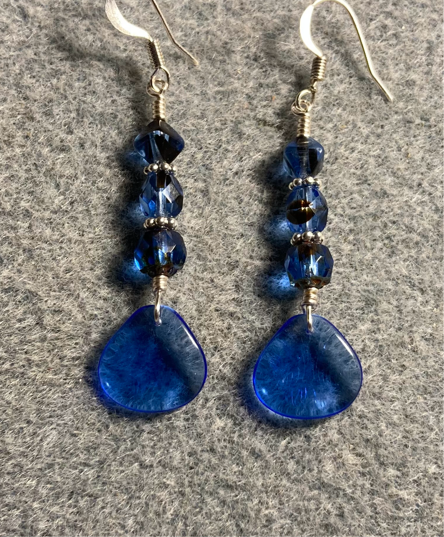 Translucent dark blue Czech glass rose petal earrings adorned with dark blue Czech glass beads.