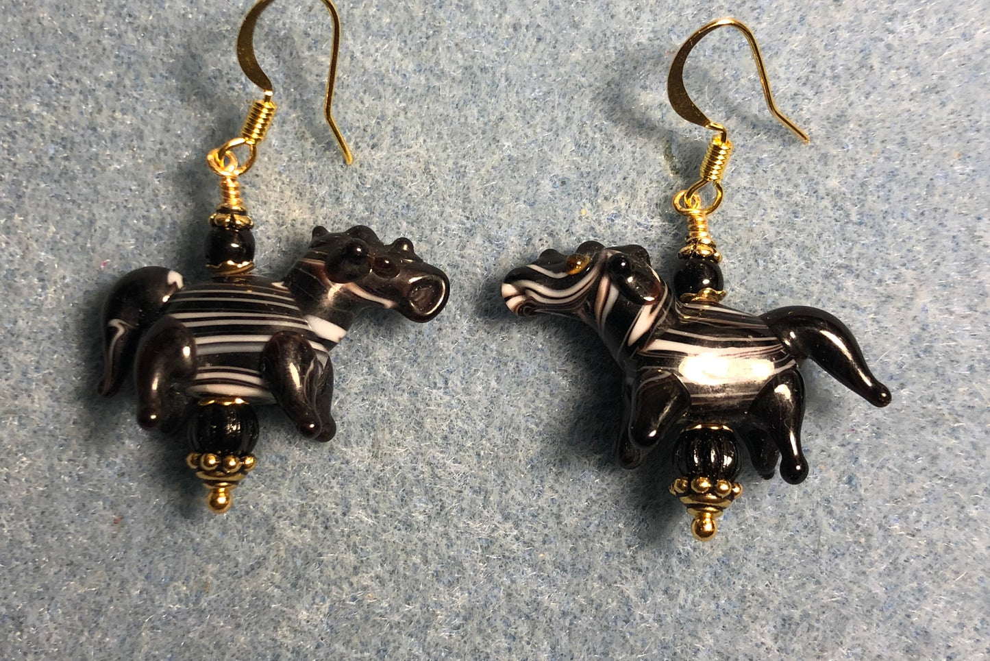 Black with white stripes lamp work horse bead earrings adorned with black Czech glass beads.