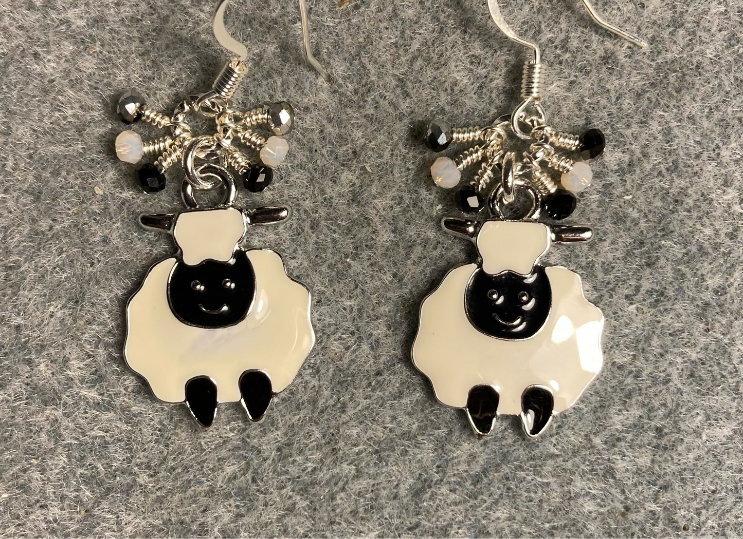 Black and white enamel sheep charm earrings adorned with tiny dangling black, white, and silver Chinese crystal beads.