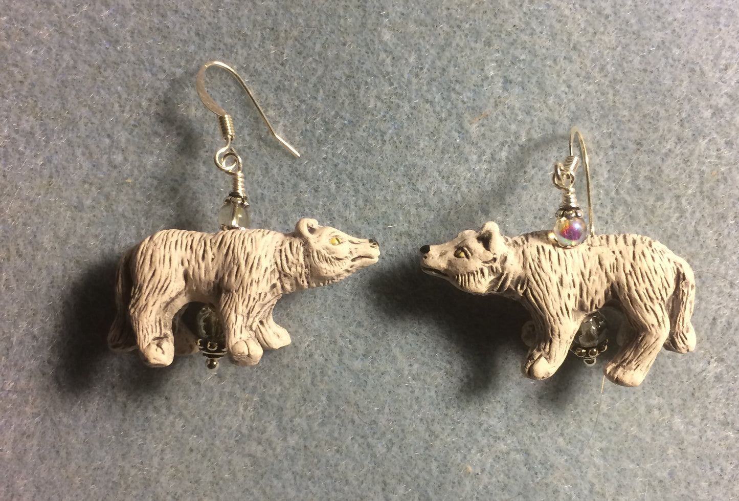 Off white ceramic snarling wolf bead earrings adorned with gray Czech glass beads.