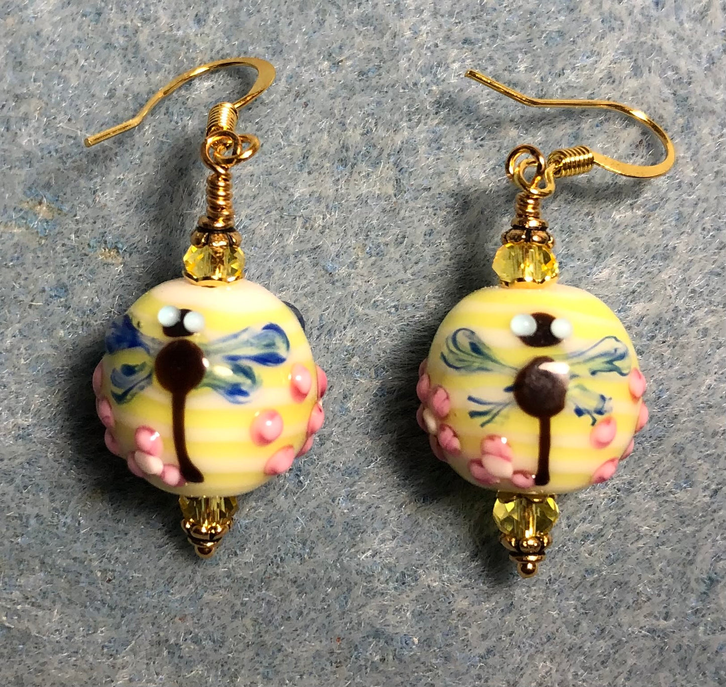 Yellow, blue, and pink lamp work dragonfly bead earrings adorned with yellow Chinese crystal beads.