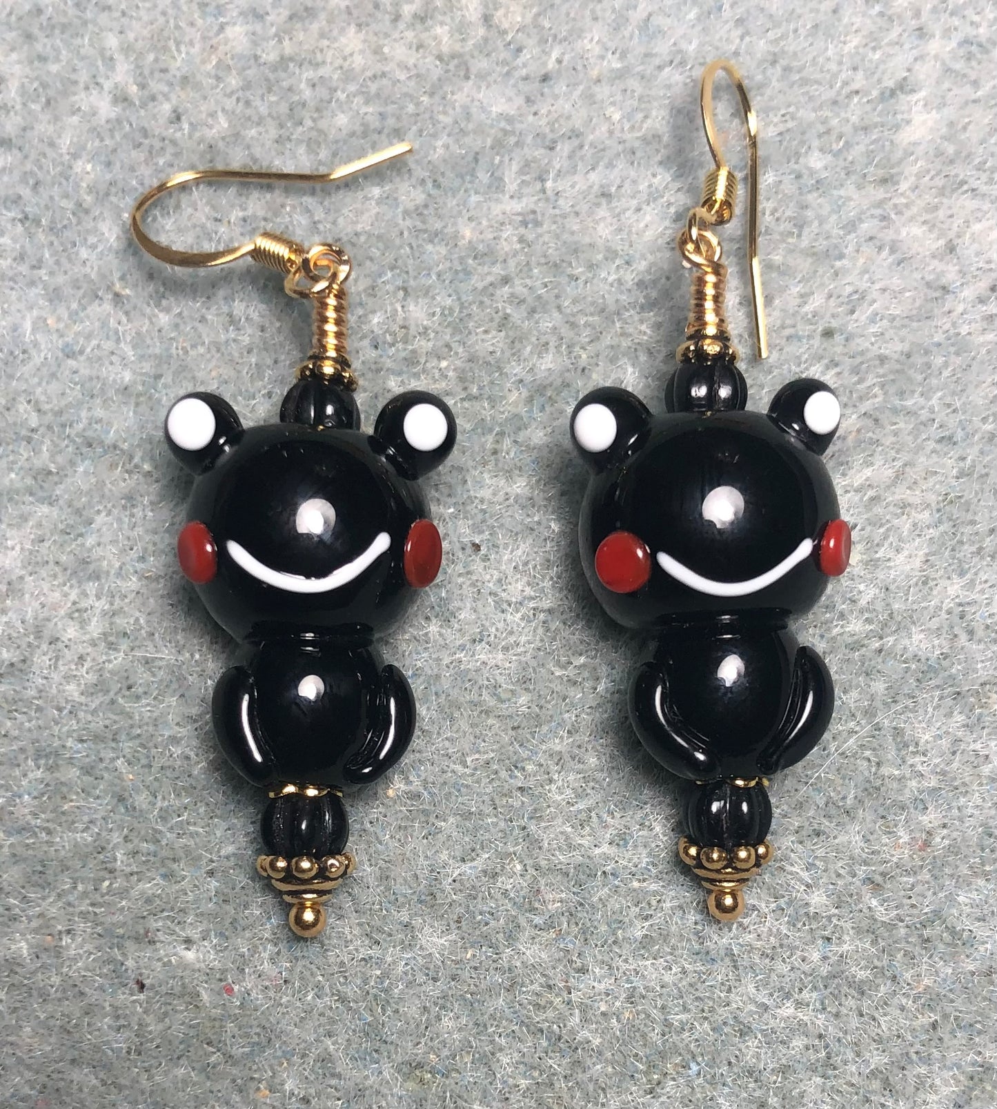 Opaque black lamp work frog bead earrings adorned with black Czech glass beads.