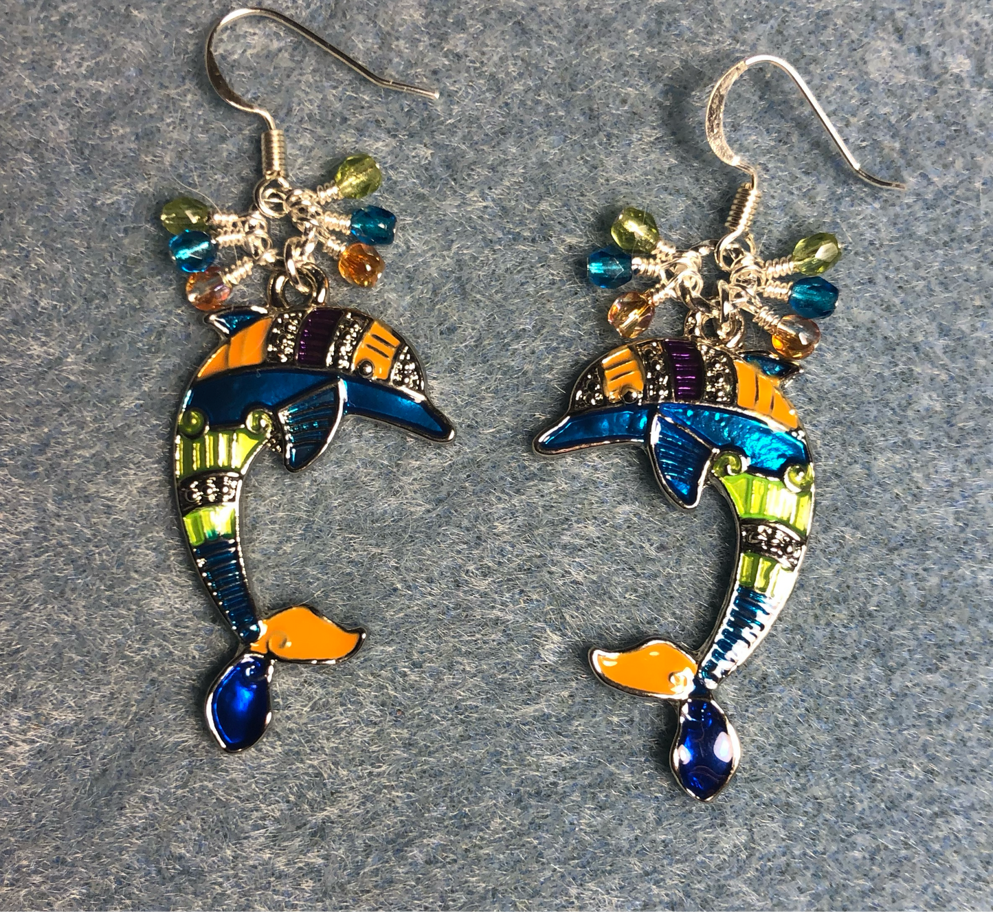 Large colorful enamel dolphin charm earrings adorned with small dangling turquoise, olive green, and orange Czech glass beads.