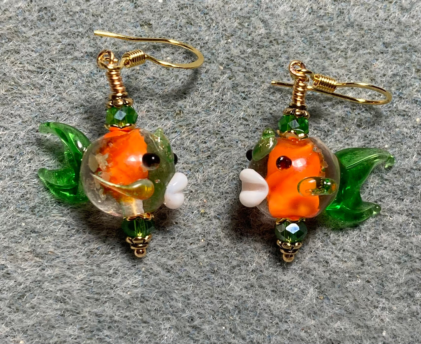 Orange and green glow in the dark lamp work fish bead earrings adorned with emerald green Chinese crystal beads.
